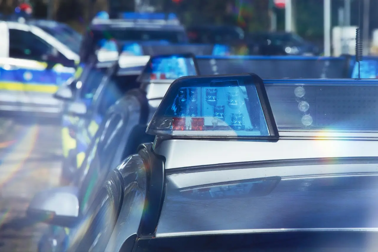 Poliisiauto liikenteessä, valot vilkkuvat hätätilanteessa.