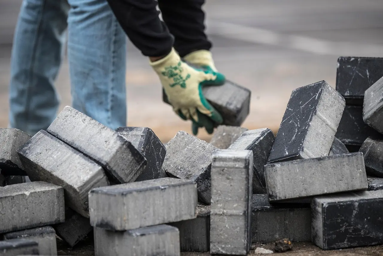 Rakennusmateriaaleja työmaalla, taustalla näkyy rakentamisen edistyminen.