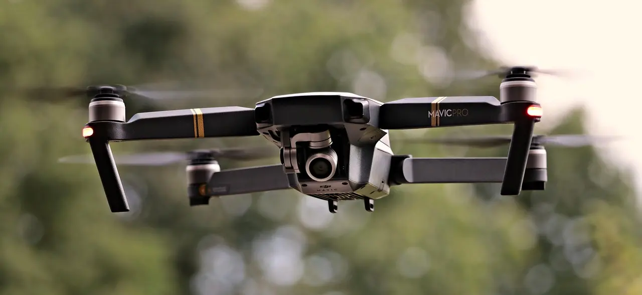 Dronen ohjaaja tarkkailee lennokkiaan monitoreilta ja ohjaimista.