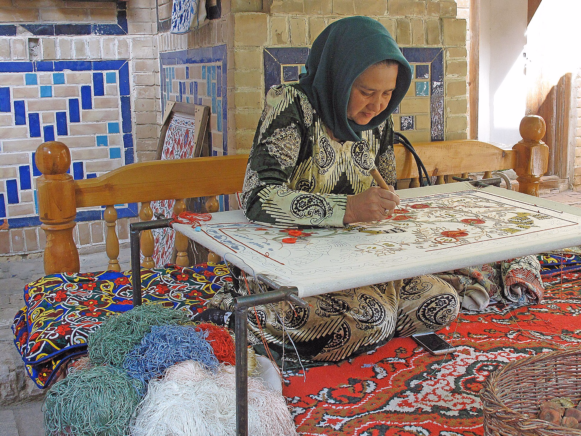 163 Madrassa d'Ulug'bek (Bukharà), dona fent un teixit artesanal al pati